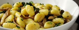 Eine Schale mit gebratenen Gnocchi mit Pilzen.