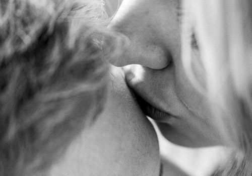 Junge Frau küsst ihren Freund auf die Stirn