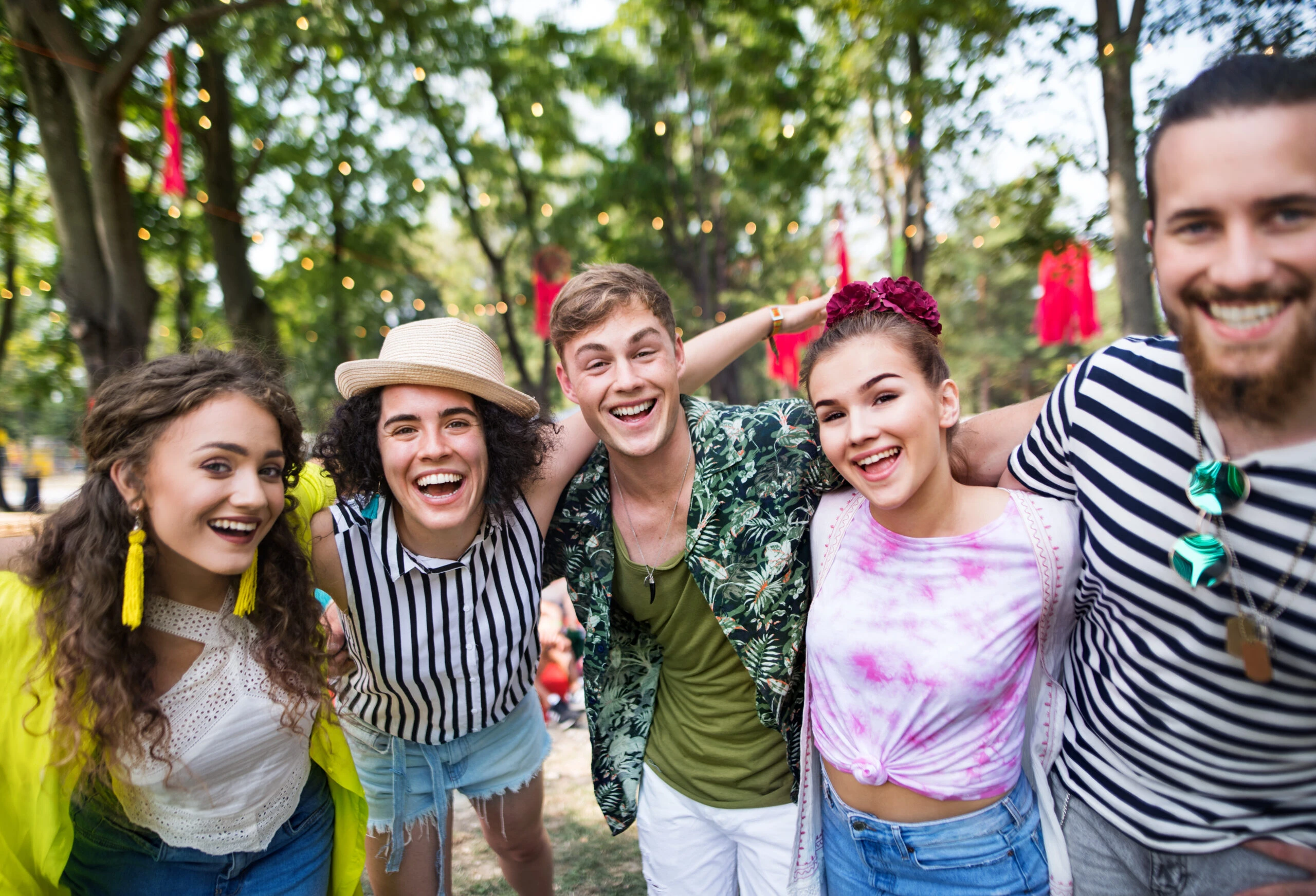 Eine Gruppe junger Freunde auf einem Sommerfest, die in die Kamera schauen.