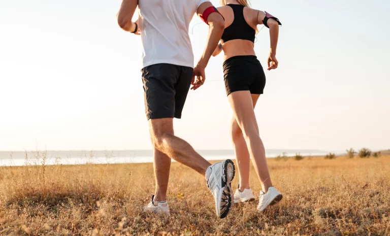 Ein Mann und eine Frau die über eine Wiese joggen