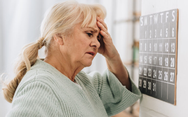 Eine Frau schaut bedrückt auf ihren Kalender, da sie sich Sorgen um ihren Kontrolltermin nach der Nierentransplantation macht